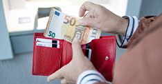 person taking euros out of their purse