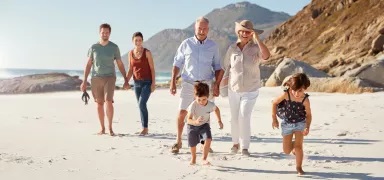 3 generation family strolling on the beach